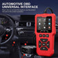 Red OBD2 scanner plugged into car dashboard socket, with screen and control buttons