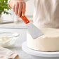 Stainless steel cake spatula with wooden handle, spreading frosting on a round cake