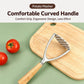 Potato masher with curved gray handle and oak grip lying across a wooden cutting board