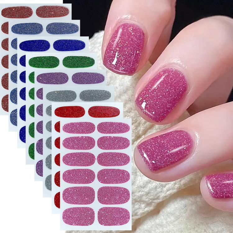 Pink glitter nail stickers on nails, with multiple sticker sheets in the background.