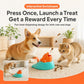 Teal whale-shaped treat-launch toy with orange spout, with dog and cat nearby