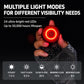Round red LED bike tail light with textured black body held in hand