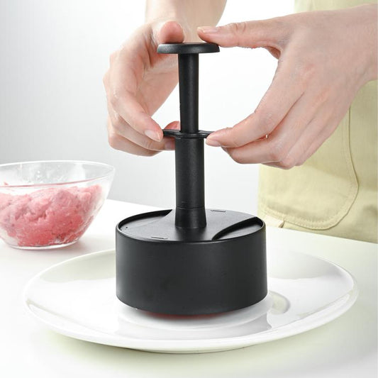 Black round hamburger patty press with base cylinder and push handle held by hands
