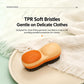 Orange and cream double-sided laundry brush on fabric with textured pad top