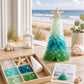 DIY sea glass Christmas tree craft with green gradient tree, instruction card, and box pieces