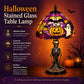 Halloween stained glass table lamp with purple shade showing pumpkin, ghost, and skeleton base.