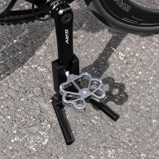 Black bike crank kickstand with folding kick feet and metal mounting bracket