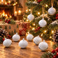 White round bell charms with black clapper and small hanging loops, on a wooden surface