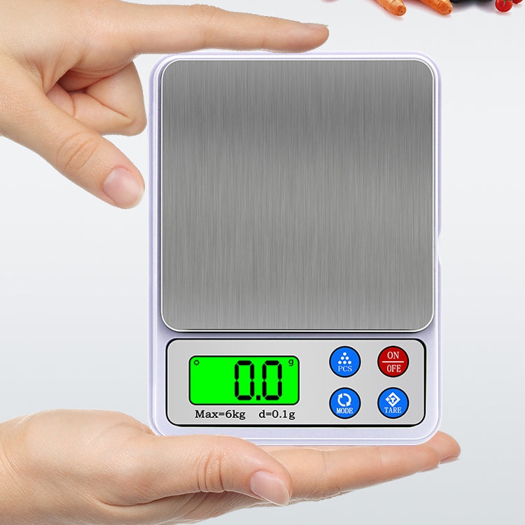 Portable digital kitchen scale held in hands, stainless pan and green LCD reading