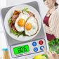 Portable digital kitchen scale with plate of fried eggs and green LCD reading 0.6 g
