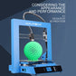 Blue desktop 3D printer showing green printed sphere in front chamber