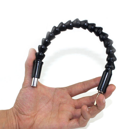 Flexible torsion shaft held in hands with black coiled body and metal tip ends
