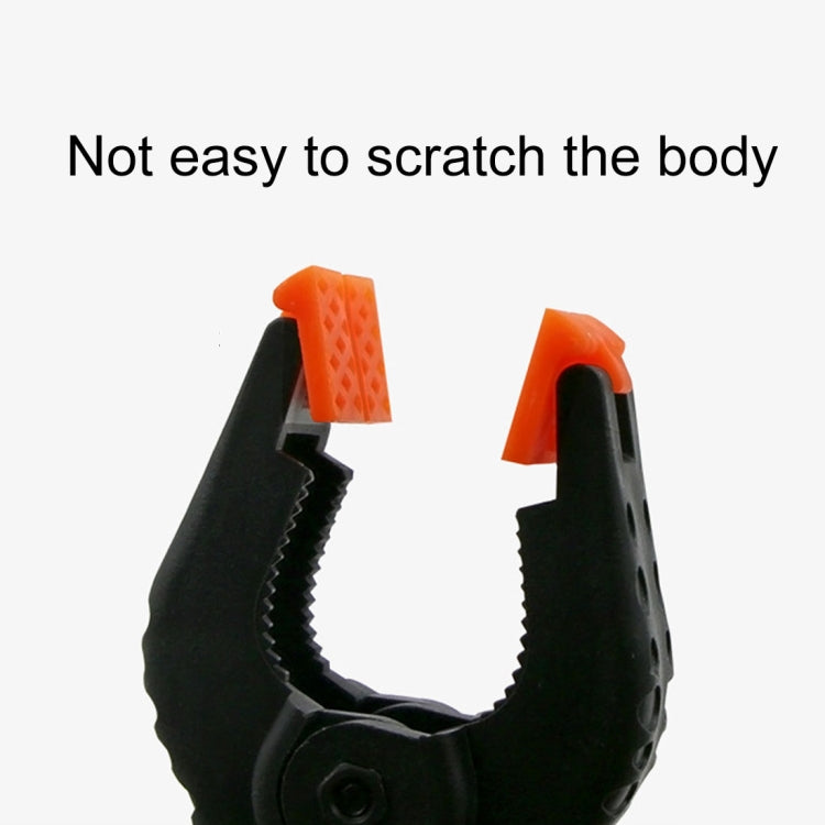 Black spring clamp jaw with orange grip inserts, secure grip detail