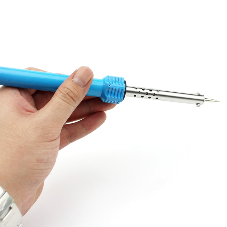 Hand holding a blue electric soldering iron with pointed metal tip