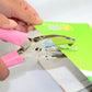 Manual hole punch applying punch to paper with pink handles and silver metal jaw