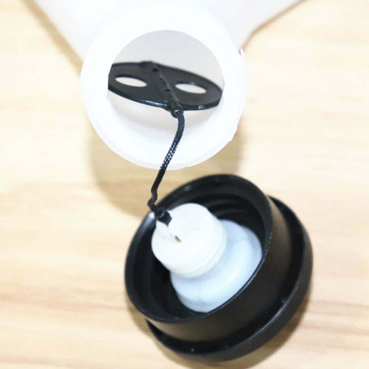 Fuel tank oiler assembly cap with black base, white insert, and connected tube