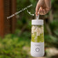 White portable USB mini juicer blender bottle with fruit pieces inside