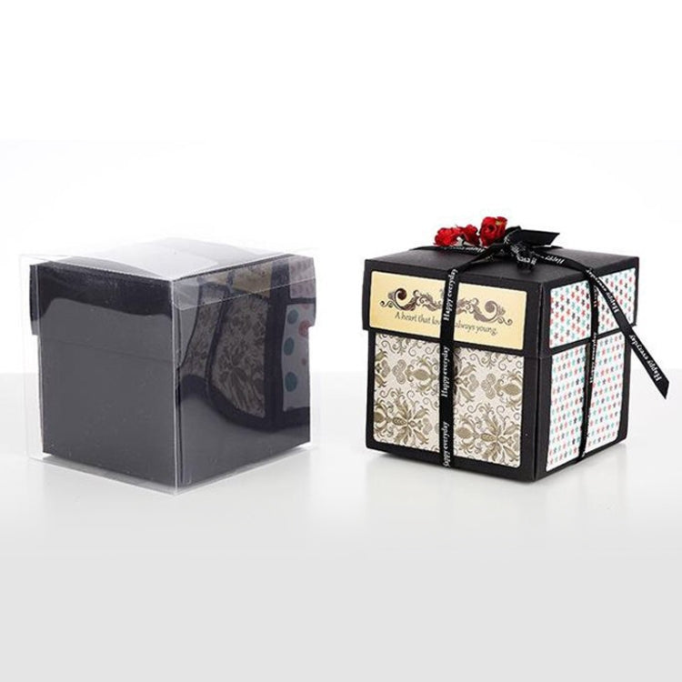 Two packaged black photo album explosion gifts with ribbon, one in clear wrap