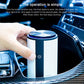 Blue-lit top cylindrical car air purifier with power button, being pressed