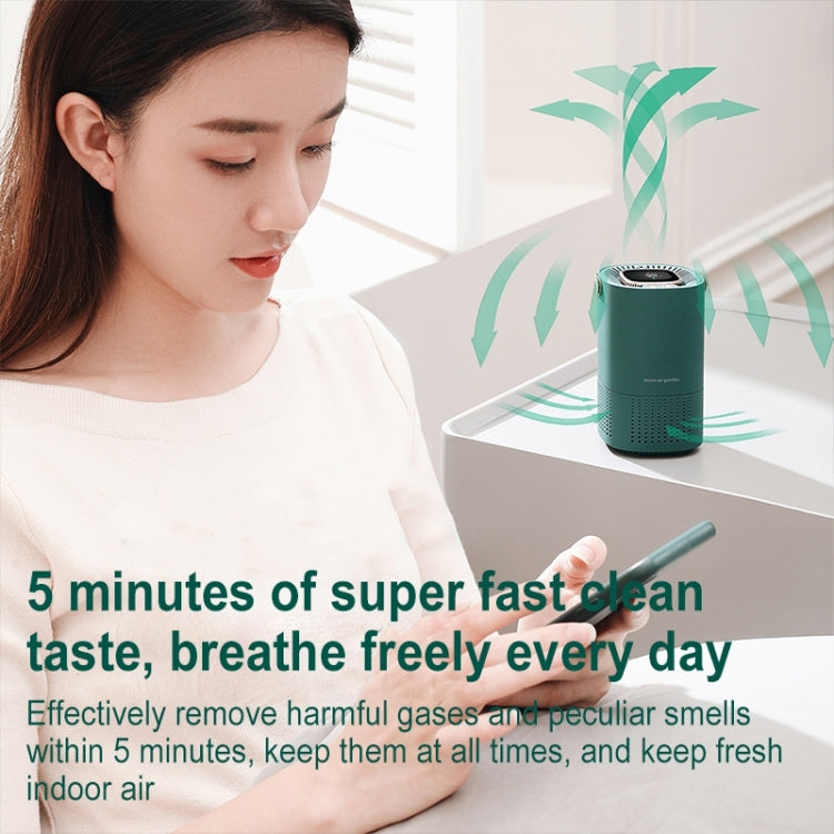 Green portable air purifier with top display and carrying handle on table