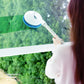 Telescopic electric window cleaner spraying and scrubbing glass surface with blue brush