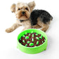 Green anti-choking pet food bowl on floor, filled with kibble and green pieces