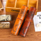 Orange printed pencil roll case with compass design, shown beside wooden storage box