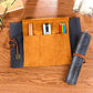 Tan multi-slot pencil bag with dark side sleeve and compass rolled case
