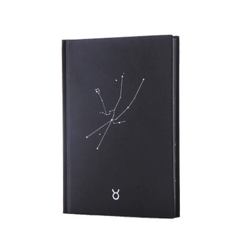 Black paper notebook cover with constellation line art and small zodiac symbol at bottom