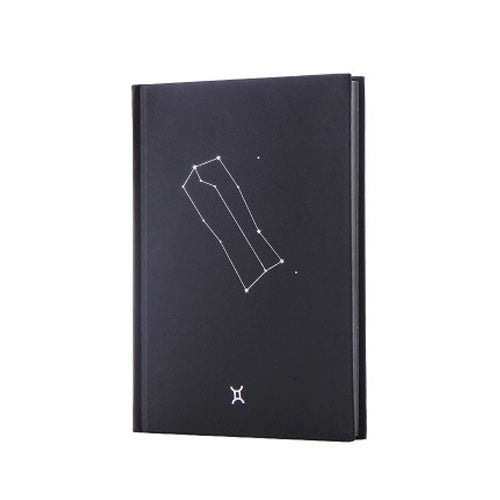 Black paper notebook cover with constellation outline art and small zodiac symbol at bottom