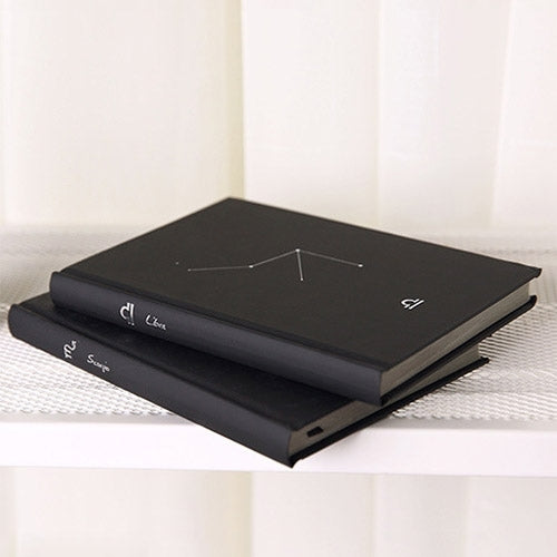 Stacked black paper notebooks with constellation symbols on the top cover