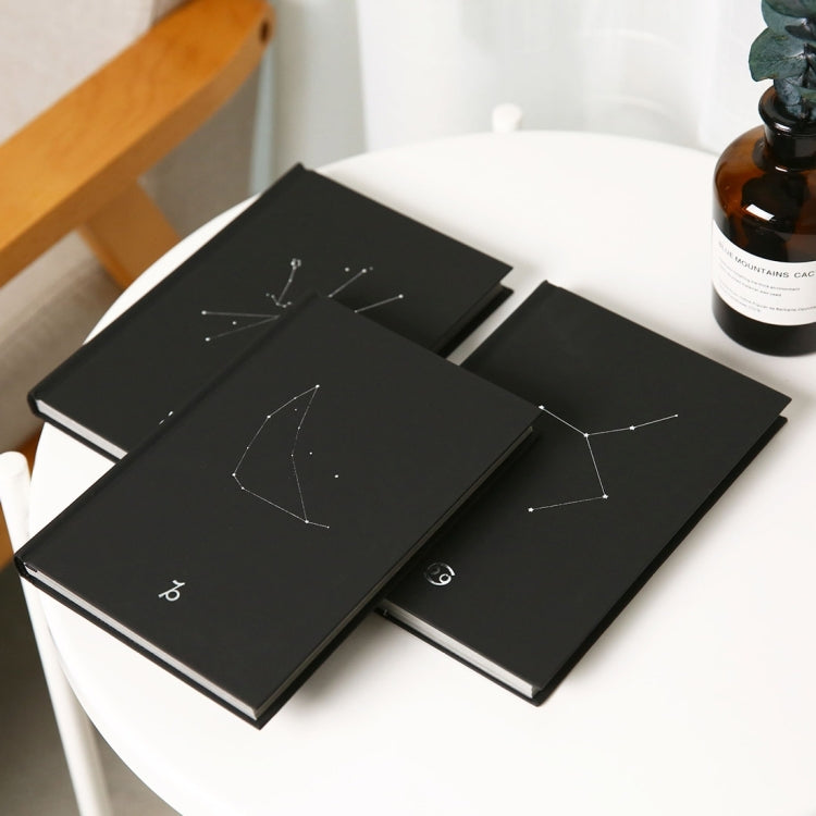 Set of black paper notebooks with different constellation line art designs