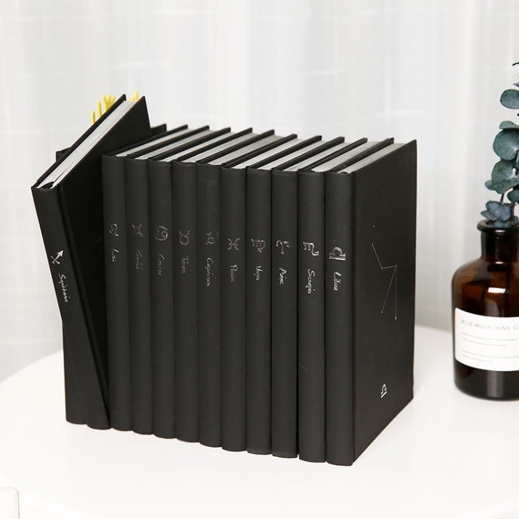 Black notebook set standing upright with printed constellation icons on spines
