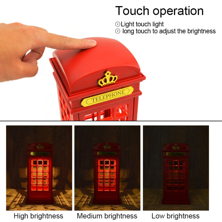 Hand touching the top of a red phone booth lamp for touch control; crown detail.