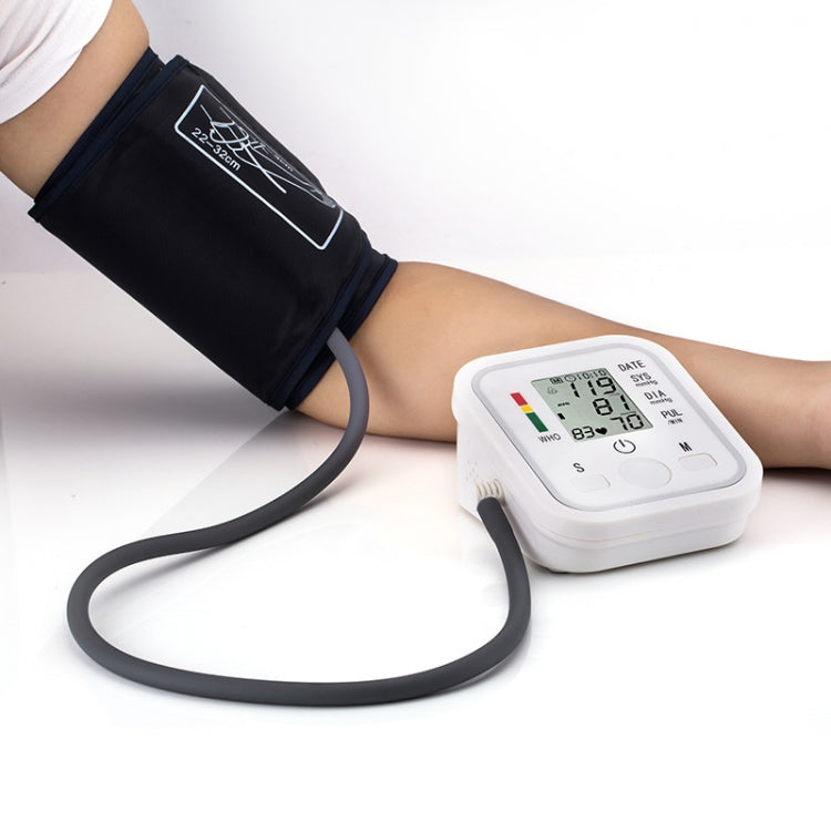 Upper arm blood pressure monitor on arm, black cuff and white LCD display