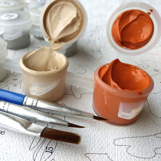 Paint jars with beige and orange paint, plus brushes on a numbered canvas
