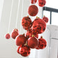 Hanging red and burgundy plastic ornament balls with gold-tone caps and hooks.