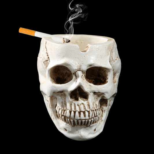 Off-white resin skull ashtray with cigarette and smoke rising from top