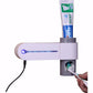 Automatic toothpaste dispenser with UV indicator light bar and tube holder above toothbrush slot