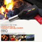 BBQ hand air blower with black handle, red vent, and metal nozzle near flames