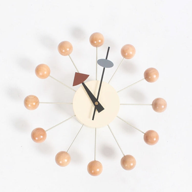 Wall clock with peach ball arms, cream face, black hands and brown triangular marker