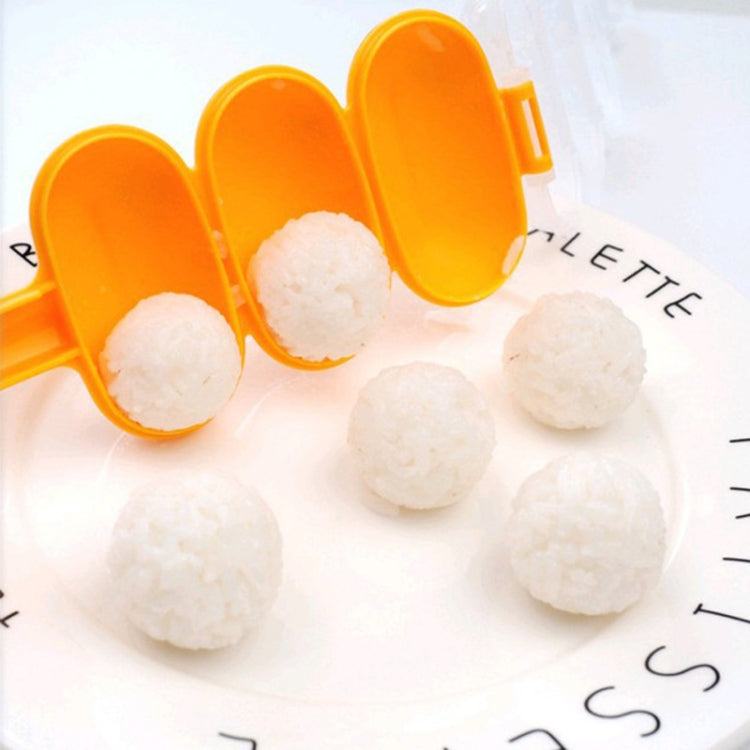 Orange spoon-shaped sushi rice ball mold holding three rice balls