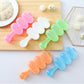 Pastel spoon-shaped sushi rice ball molds holding rice balls in assorted colors