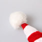 Close-up of red-and-white striped pet hat cone with white fluffy top
