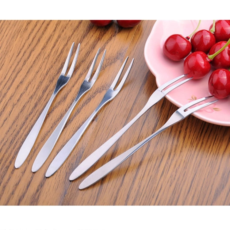 Stainless steel fruit forks set with curved handles, four shown on tabletop