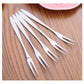 Stainless steel fruit fork set, multiple forks fanned out on wooden surface