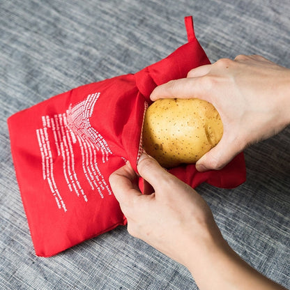 Red microwave potato cooker bag holding a potato inside with drawstring opening