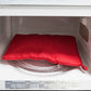 Red microwave potato cooker bag inside a microwave on the turntable