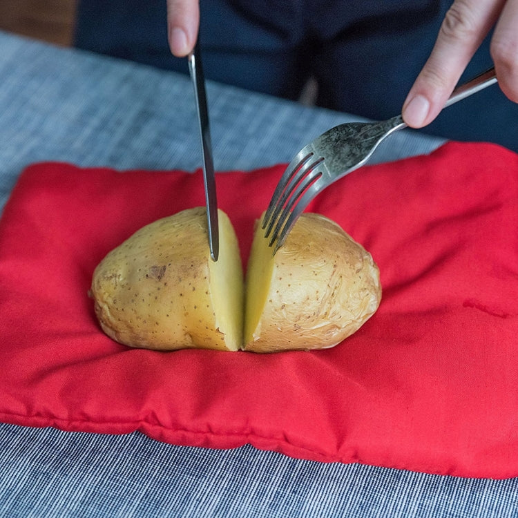 Red potato cooker bag with two potatoes and a knife over the opening
