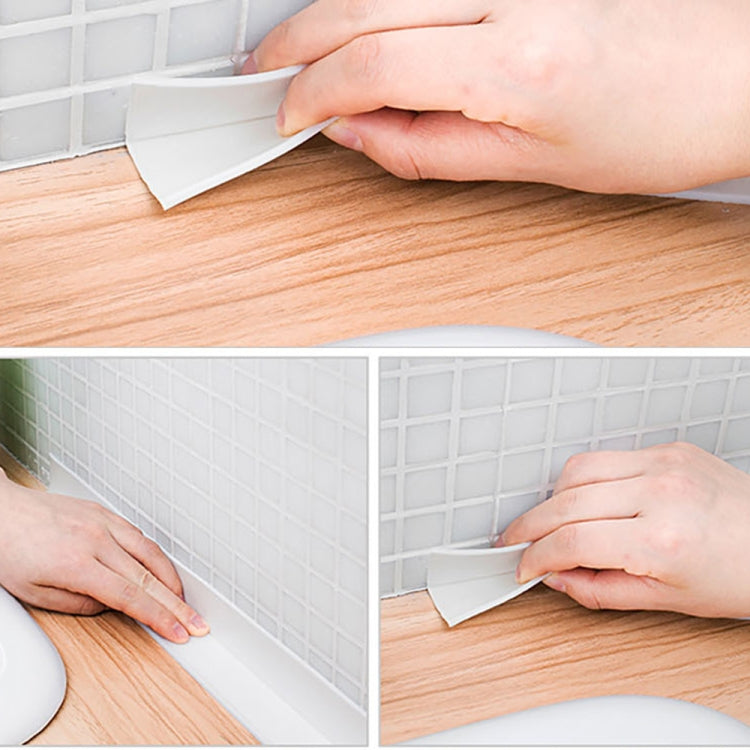 White PVC waterproof sealing tape strip being applied along tile and wood trim